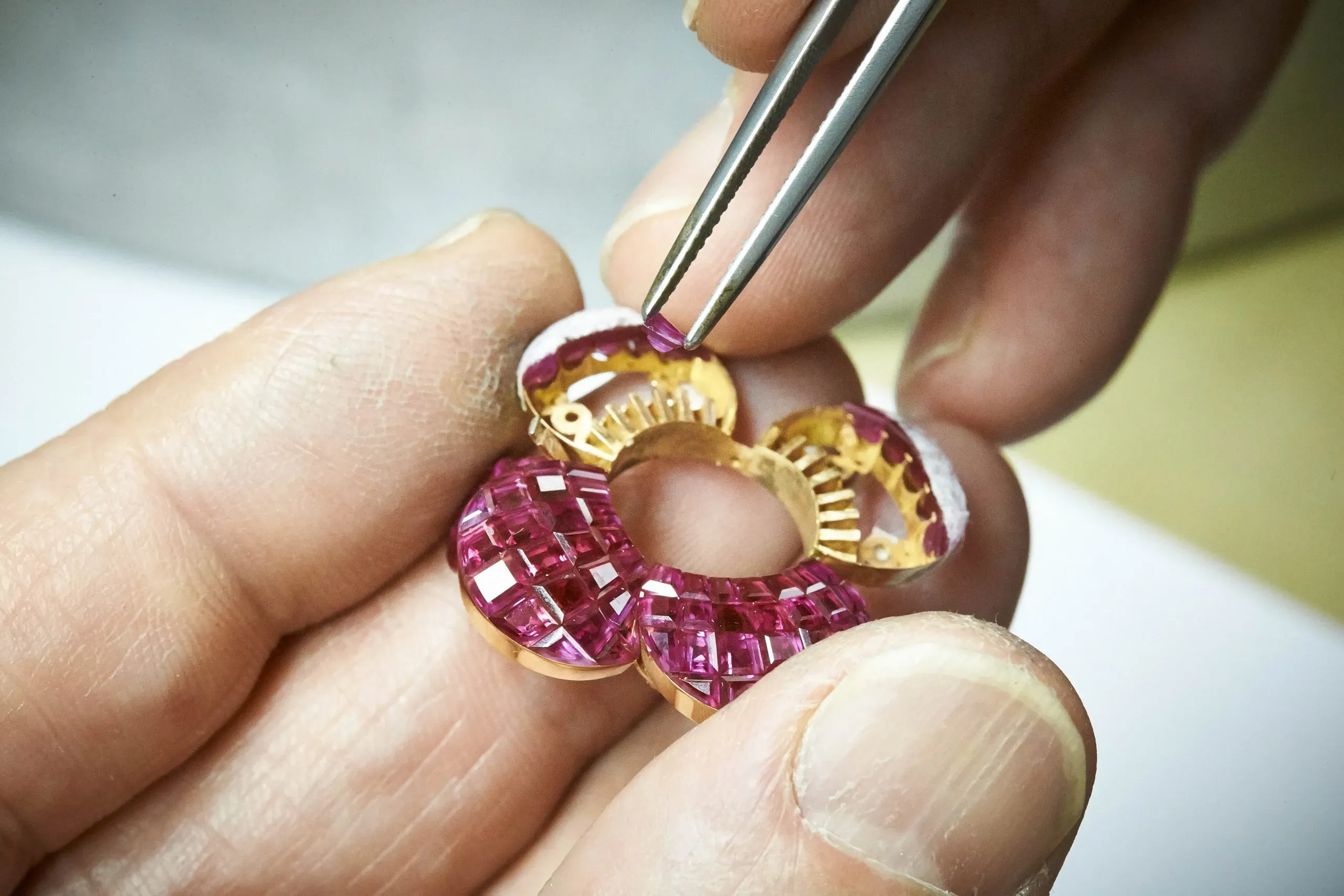 The calibrated rubies are delicately slid into grooves cut into a fine network of gold rails, each thinner than a human hair