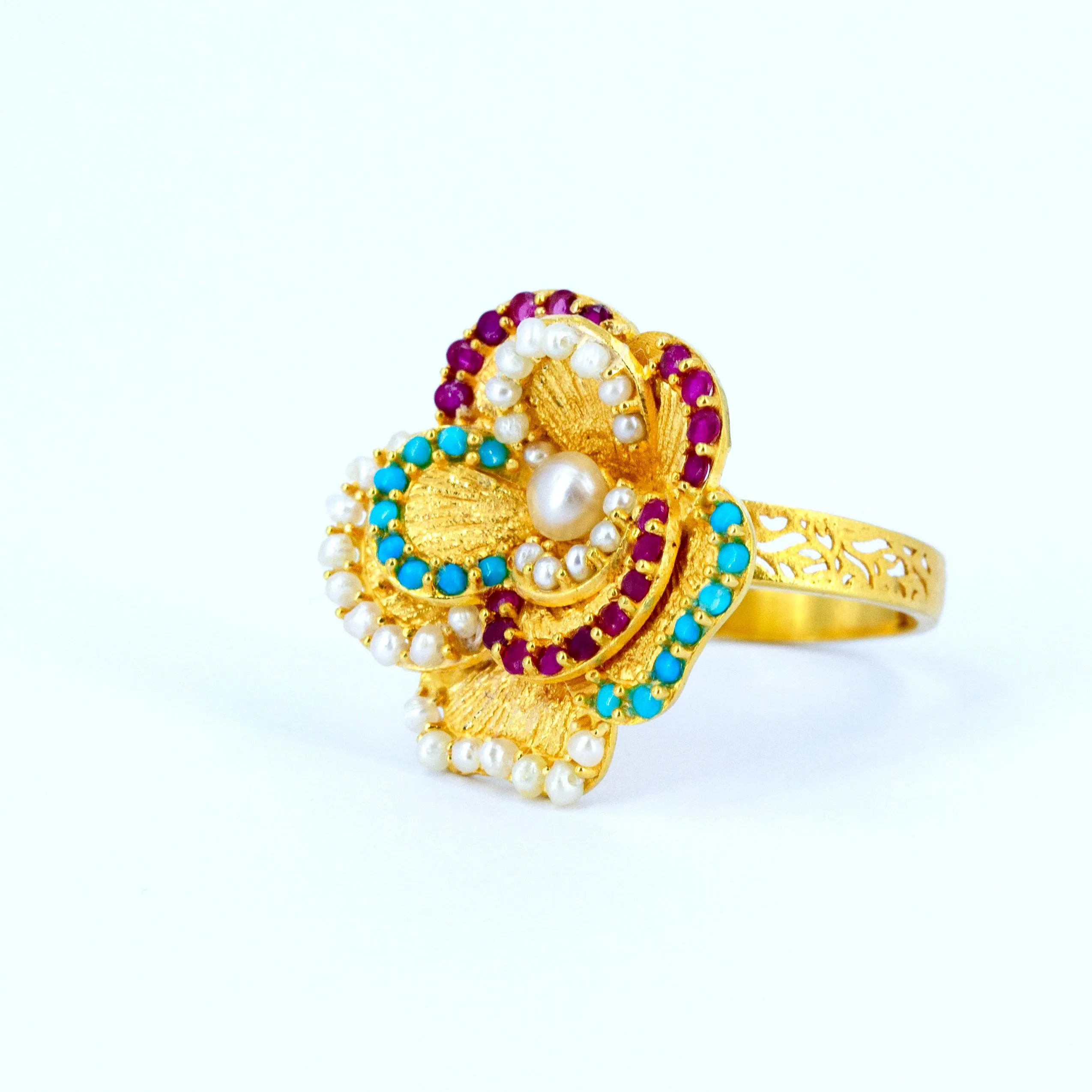 Pearl Biography ring in 21k gold with natural Bahraini pearls, turquoise, rubies and a large pearl centre