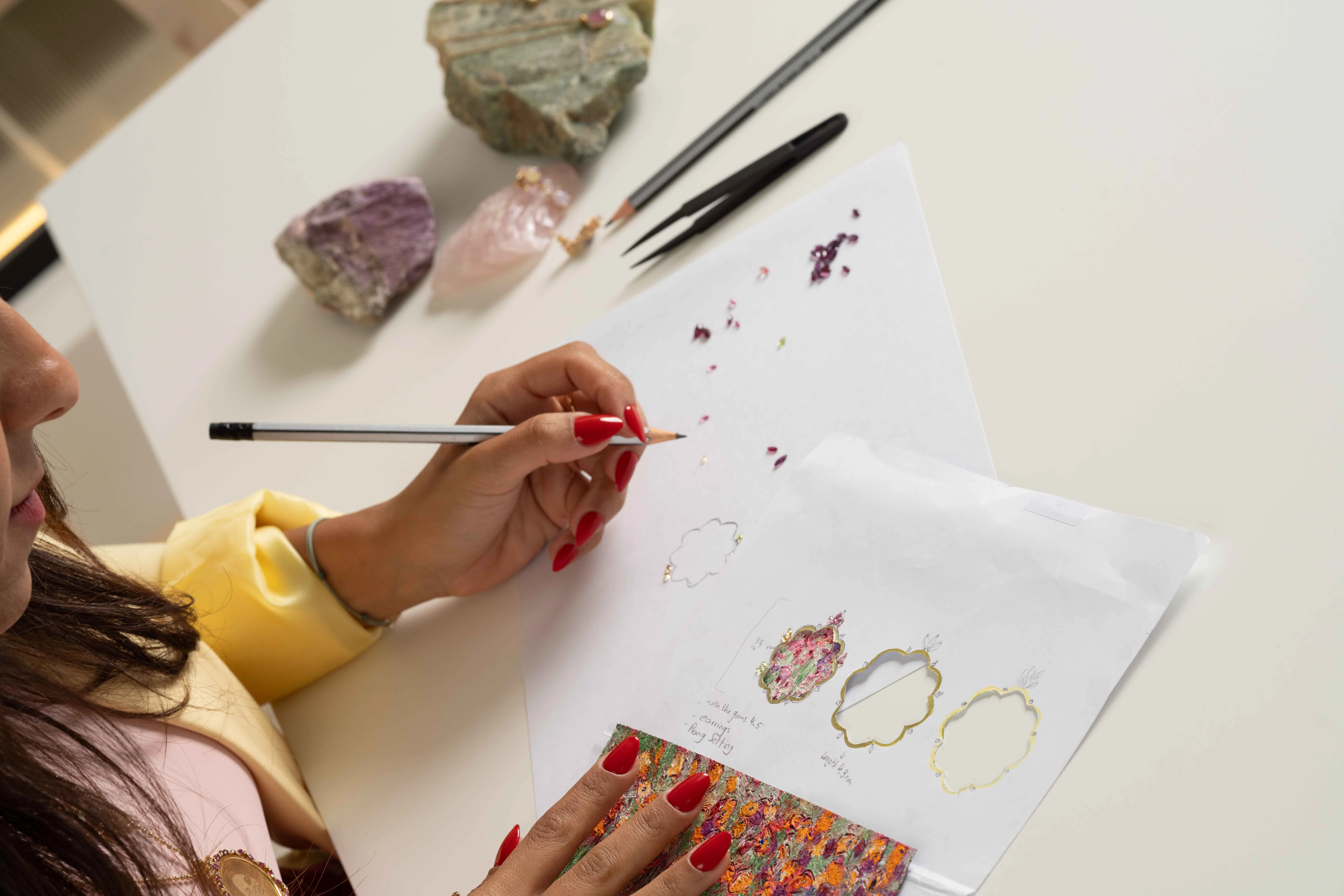 Kyan Jewelry Founder Amal Sanad designing 'The Secret Garden' Harmony necklace with an oil painting by Dr. Mayasa Al Sowaidi alongside champagne diamonds and tourmalines in 18k gold 