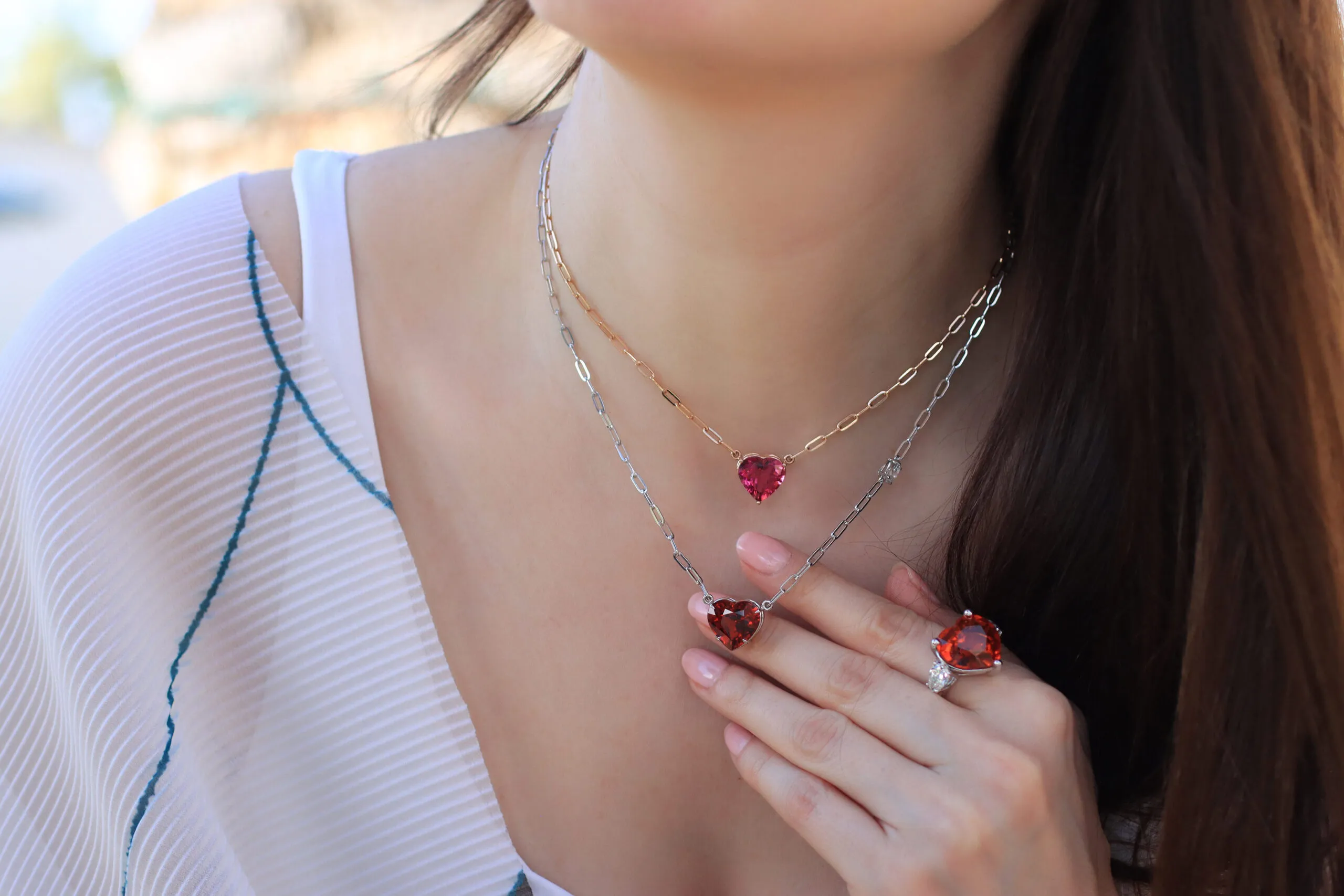 Katerina Perez wears a selection of heart-shaped gemstone pendants from the Rocks collection by Lisa Nik