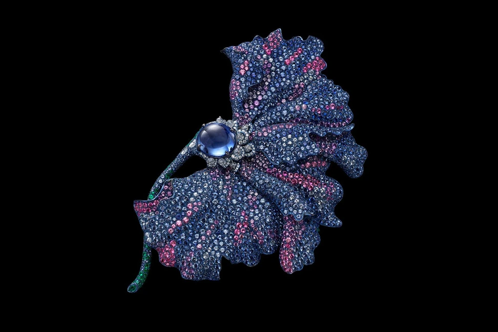 <p>Carnet brooch with an unheated oval blue sapphire cabochon, pink, purple and blue sapphires, emeralds and diamonds set in titanum and 18K white gold</p>
