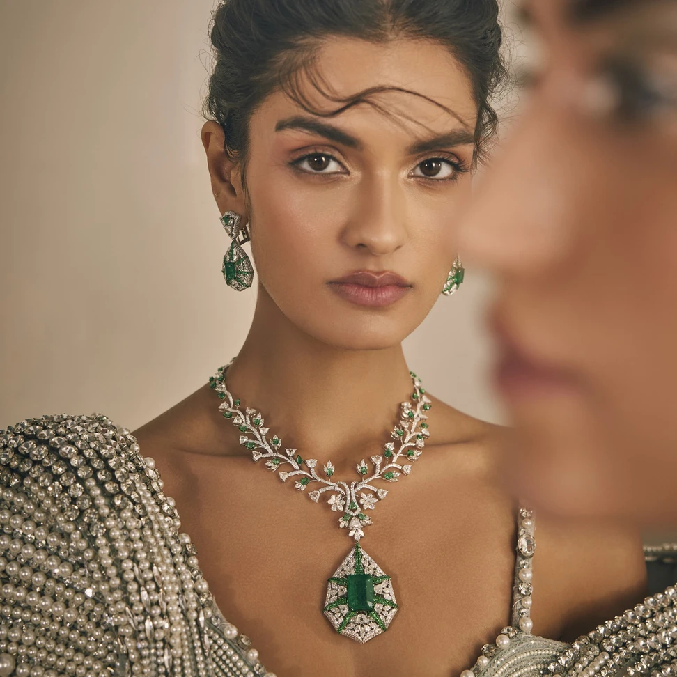 <p>Featuring a vine-work pattern crowned with custom tulip-cut diamonds, anchoring this Mrs. Marquise necklace is a verdant Zambian emerald over 20 carats</p>