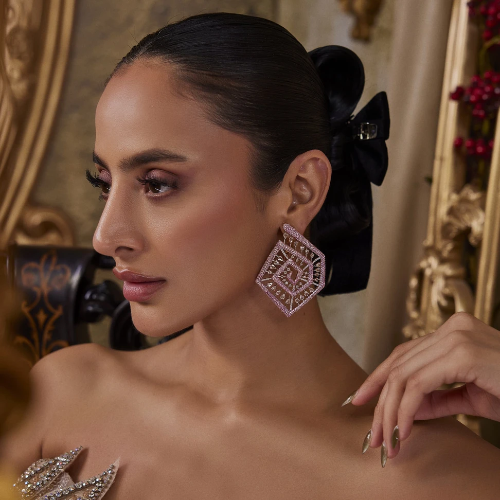 <p>White diamonds are suspended within a pentagonal spiral of pink sapphire pavé in these Mrs. Marquise earrings</p>