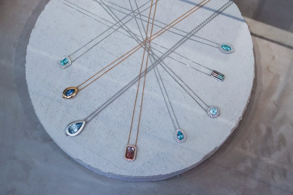 <p>A display of Jochen Leën pendants, set with Paraiba tourmalines, watermelon tourmalines, aquamarines and blue beryls</p>