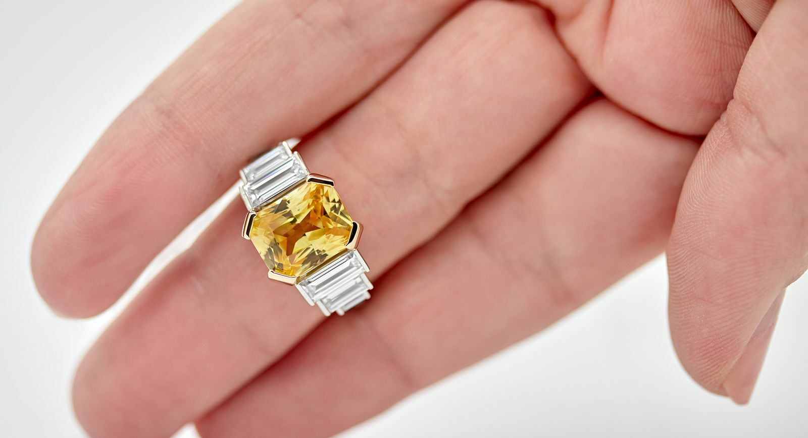 Taylor & Hart bespoke engagement ring with a 6.60 carat radiant-cut yellow sapphire and baguette-cut diamonds 