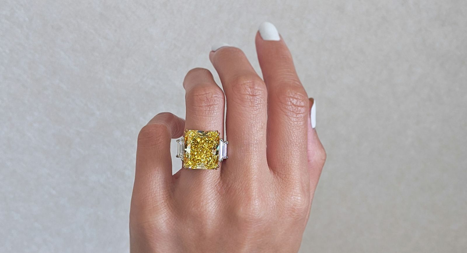 A yellow diamond and colourless diamond three-stone diamond engagement ring by Norman Silverman 