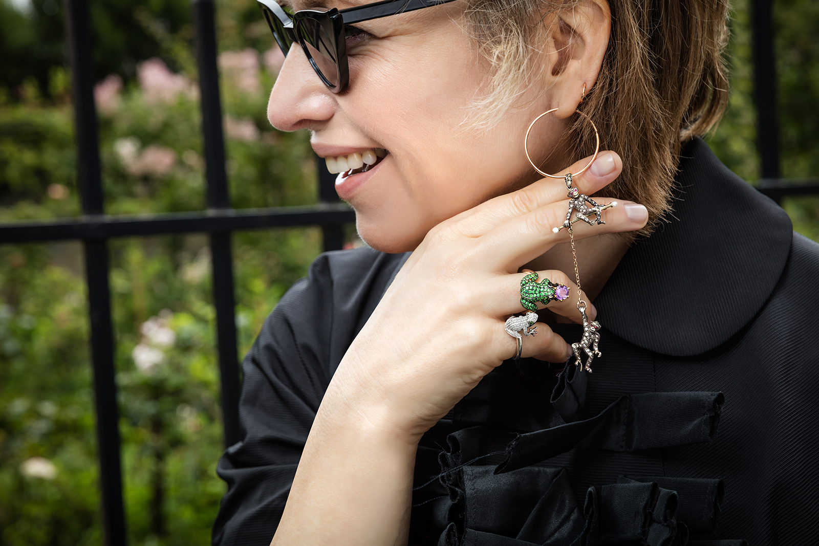  Second Pétale founder Arina Pouzoullic with frog ring (top) in demantoid garnets, amethyst and black diamonds in 18k yellow gold, and monkey pendant (attached to Arina's own hoop earring) in rose cut diamonds, red stones and pearls in 14k gold and silver