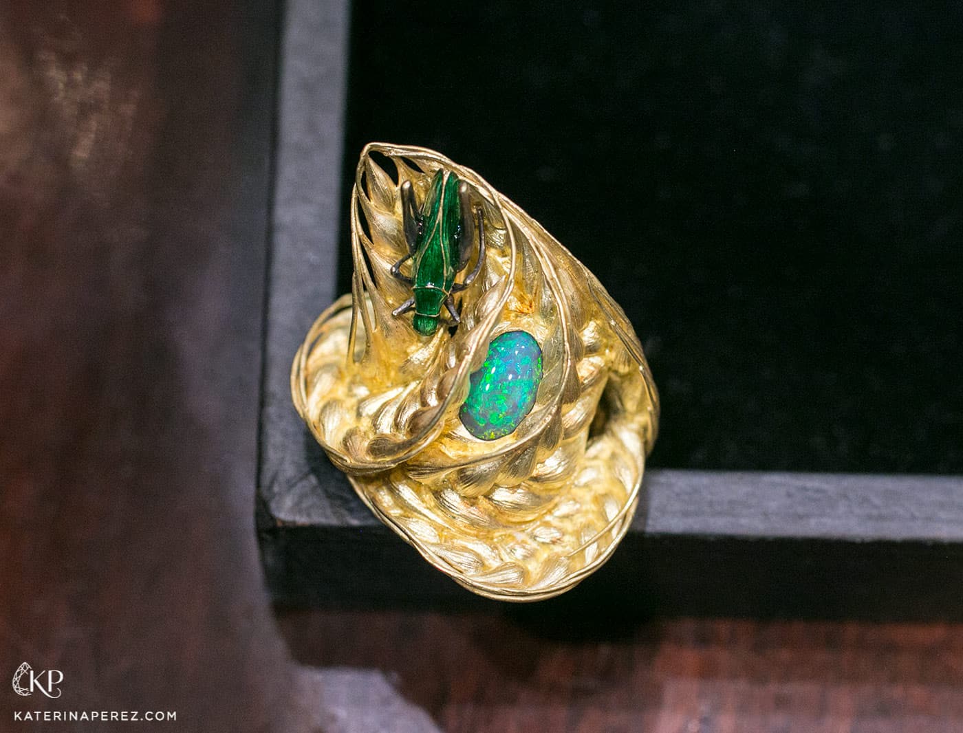  'Wind in a field' ring by Ilgiz.F made in sculptured yellow gold with enamelled grasshopper and an oval opal