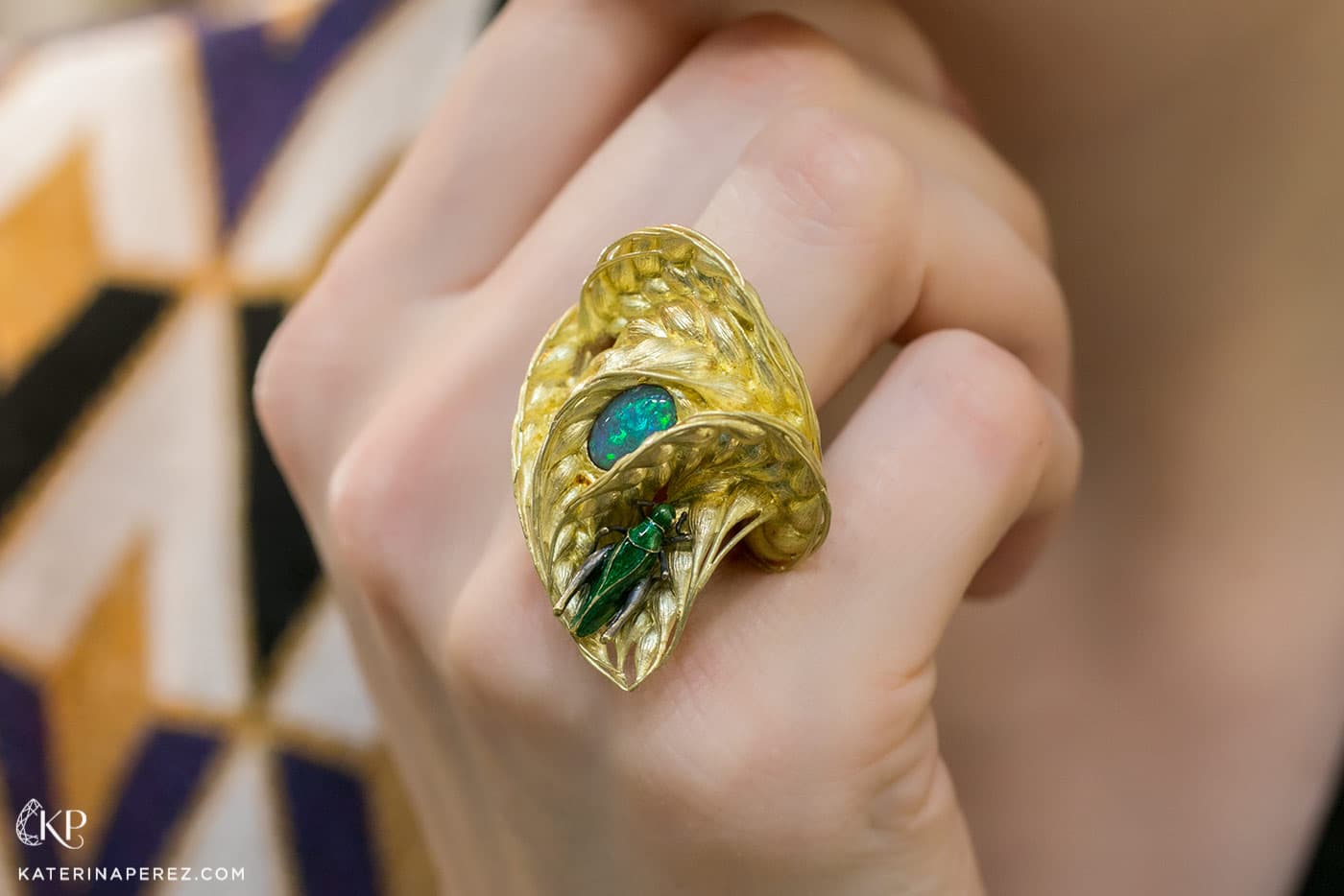  'Wind in a field' ring by Ilgiz.F made in sculptured yellow gold with enamelled grasshopper and an oval opal