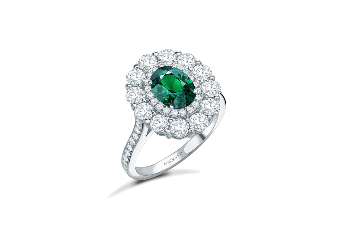  The Garrard 1735 Double Cluster engagement ring with an emerald and diamonds