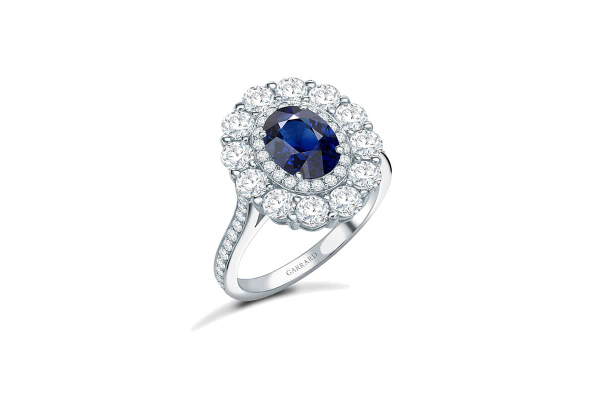  The Garrard 1735 Double Cluster engagement ring with a sapphire and diamonds