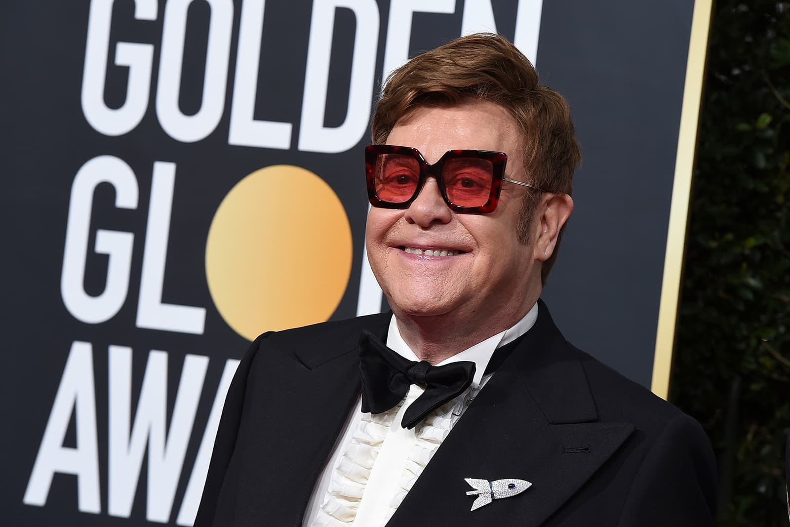 Sir Elton John wearing Theo Fennell bespoke rocket brooch with diamonds and sapphires
