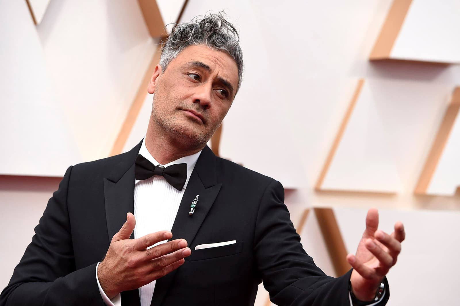 Taika Waititi wearing Nikos Koulis brooch with emerald, diamond and pearl in white gold