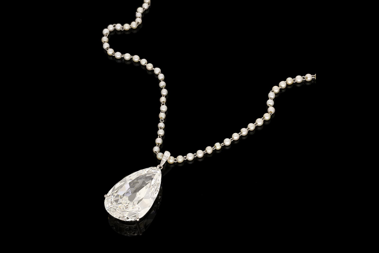  Offered by Hancocks London, a pendant with 20.20ct old cut pear-shaped diamond, accenting diamonds and pearls in platinum