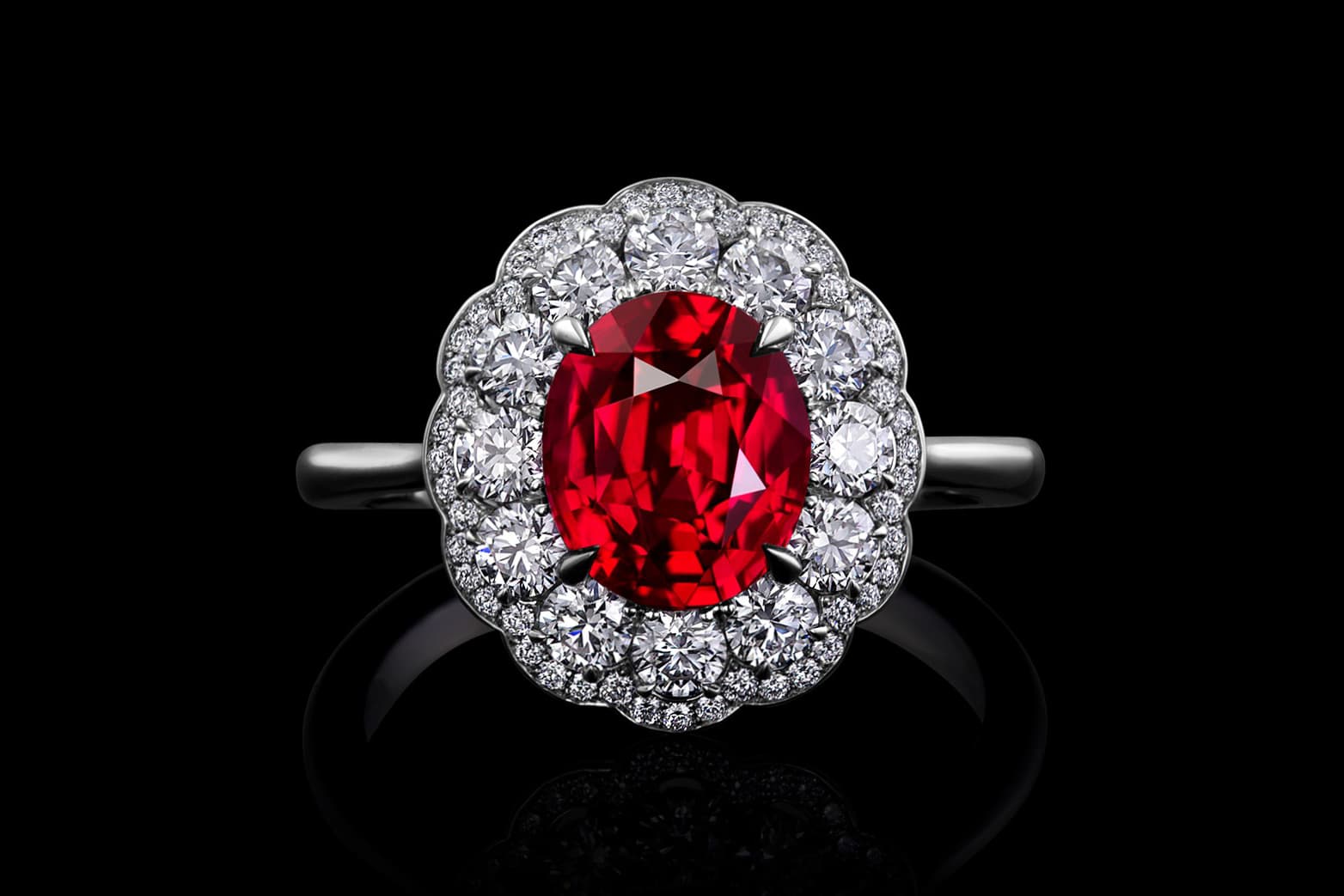  The colour of a very rare 2.30 carat oval shape Mozambique ruby is enhanced by a halo of round brilliant diamonds