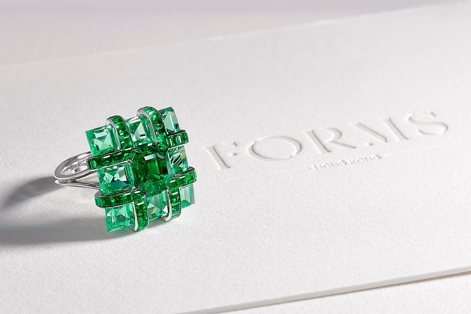 A ring from the Canvas collection featuring a 1.90 carat emerald cut Colombian emerald set within a matrix of eight carefully matched emeralds in lighter shades