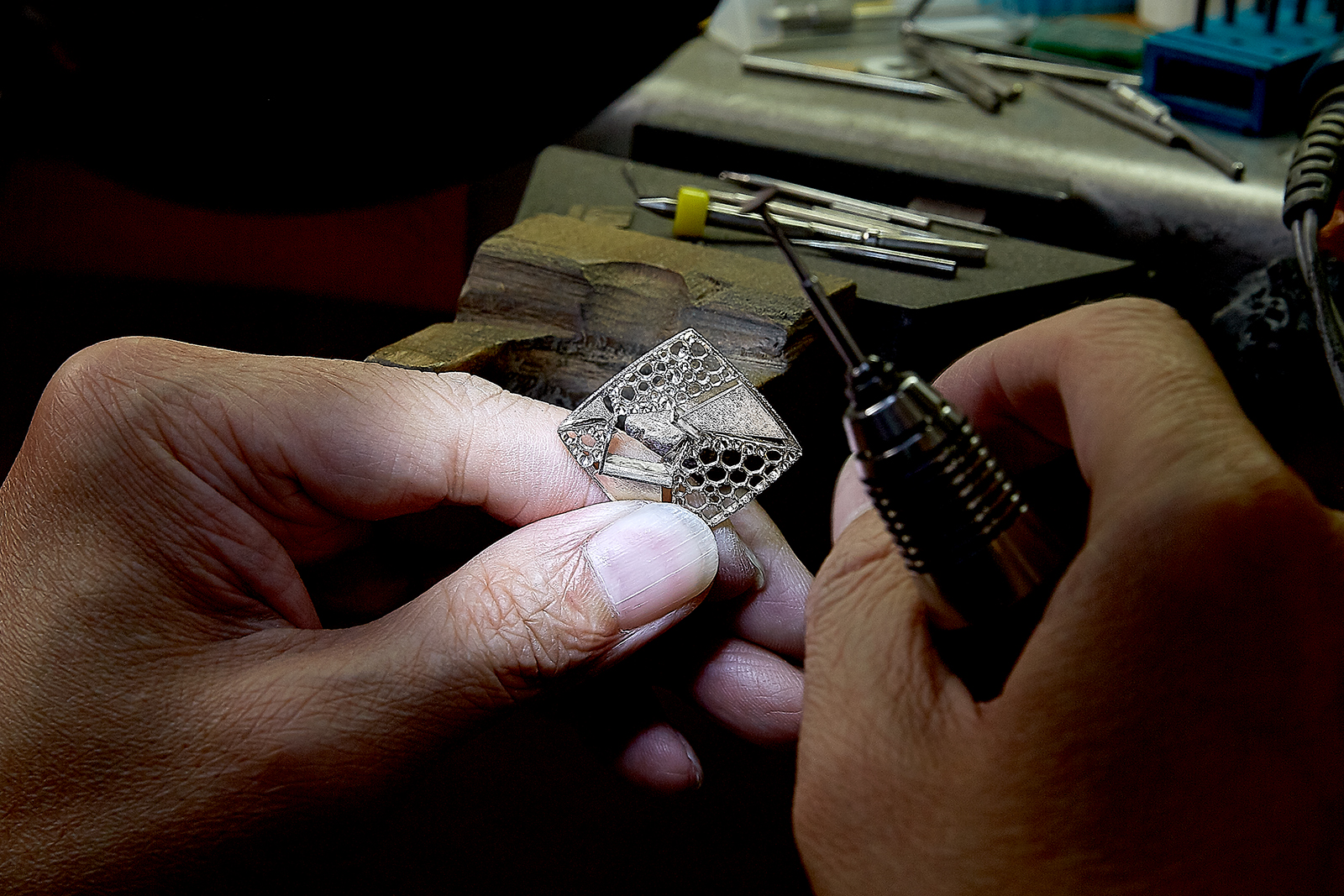  A craftsman finesses the mount for a pair of graphic earrings