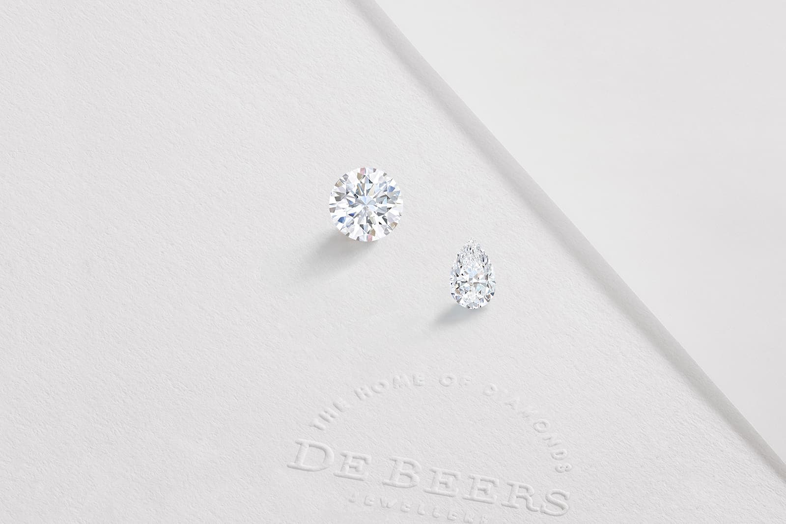  Two diamonds - a round brilliant and a cushion-cut - in the De Beers 1888 Master Diamonds Collection cut from an original rough stone of 56.38 carats
