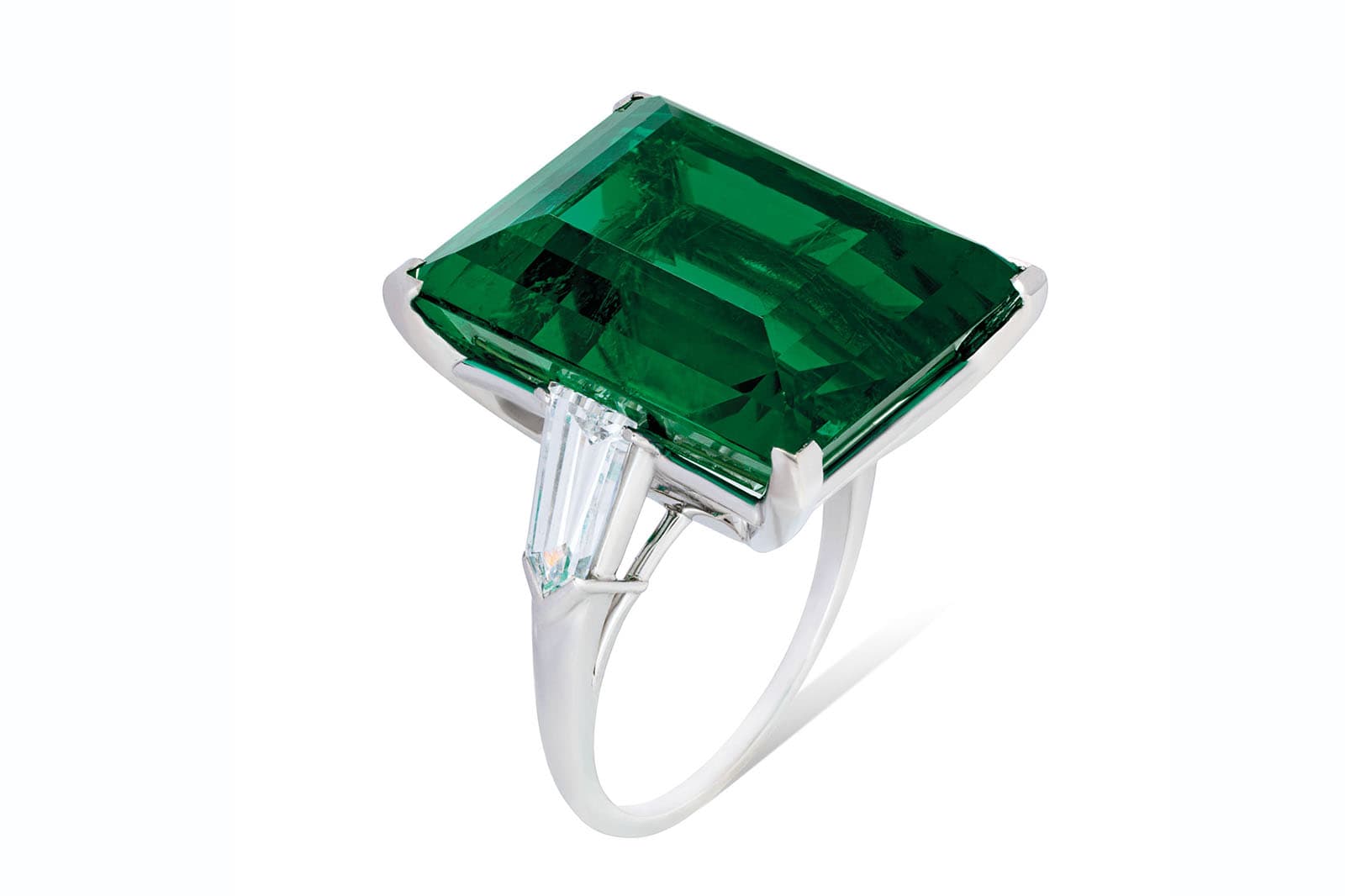  This extraordinary Colombian emerald is flanked by two bullet-shaped diamonds