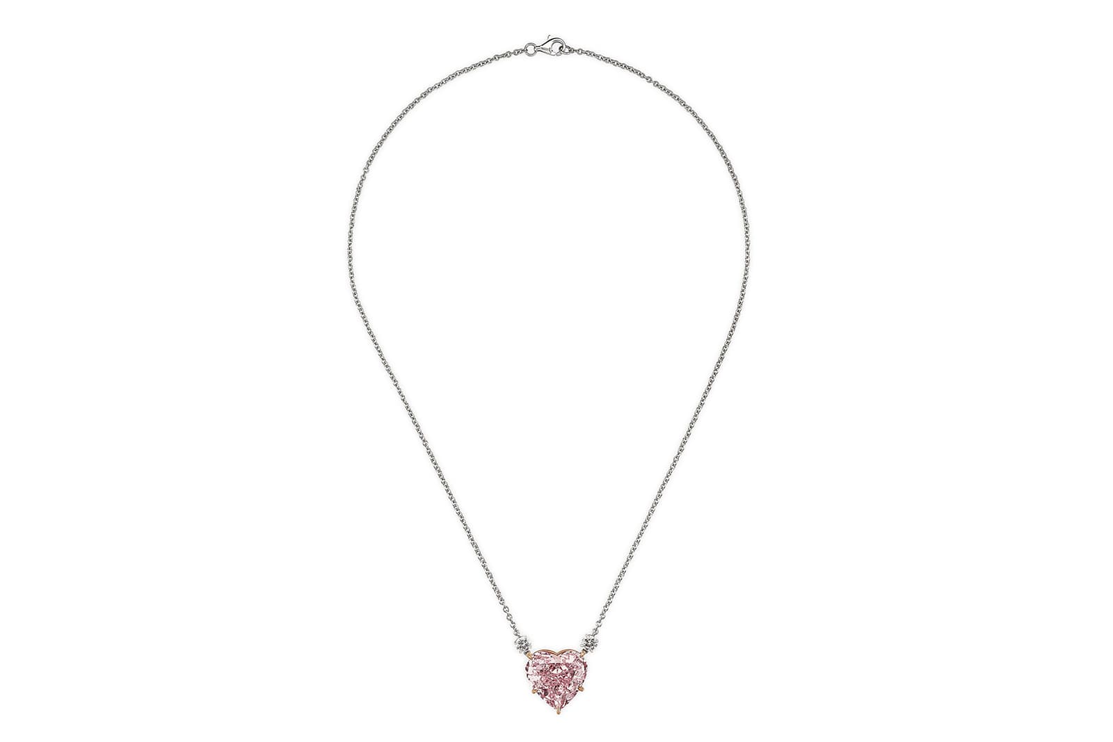  This 15.56 carat heart shaped diamond is set in rose gold and presented on a platinum chain with two round brilliant cut diamonds