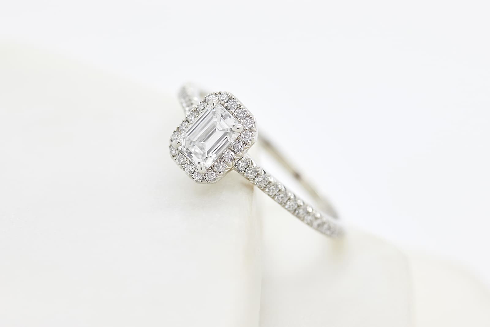  Taylor & Hart emerald-cut diamond halo engagement ring with a slim diamond pavé band
