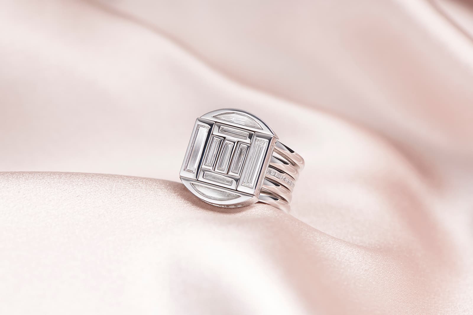 Four rings come together to create one special design featuring custom cut baguette and half moon diamonds crafted in platinum by Taylor & Hart