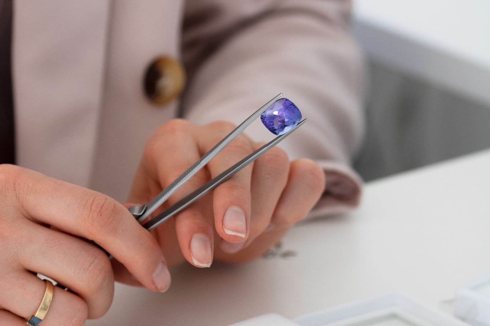 Isaline Arnoldi, one of the co-founders of GEMHYPE.COM, holds a cushion-shaped tanzanite