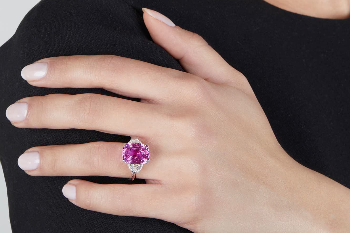  A cushion-cut pink sapphire ring of 7.37 carats, flanked by two half-moon-shaped diamonds, sold by Sotheby’s