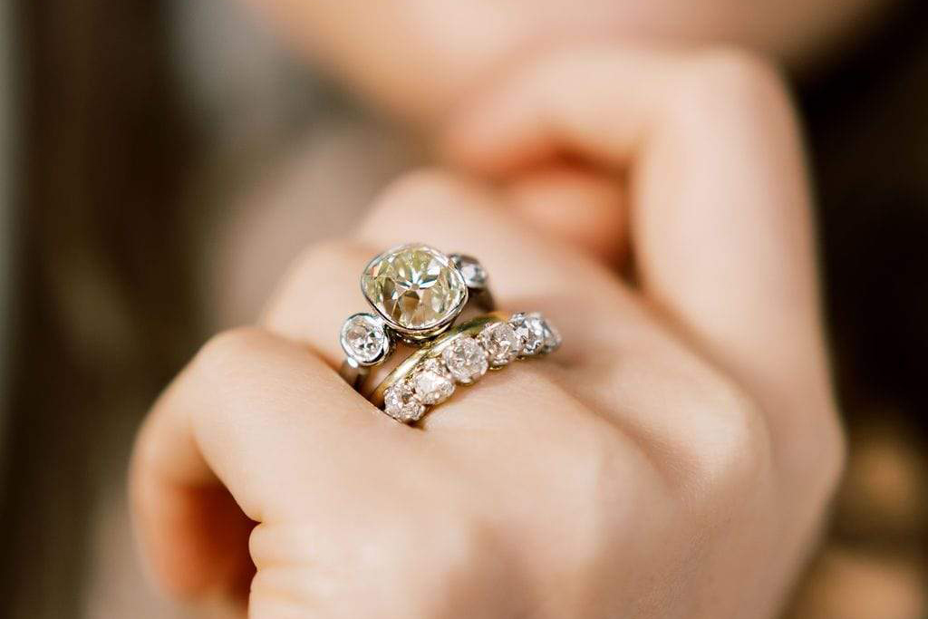  Victor Barboné three stone diamond engagement ring with a diamond-set eternity ring and yellow gold wedding band