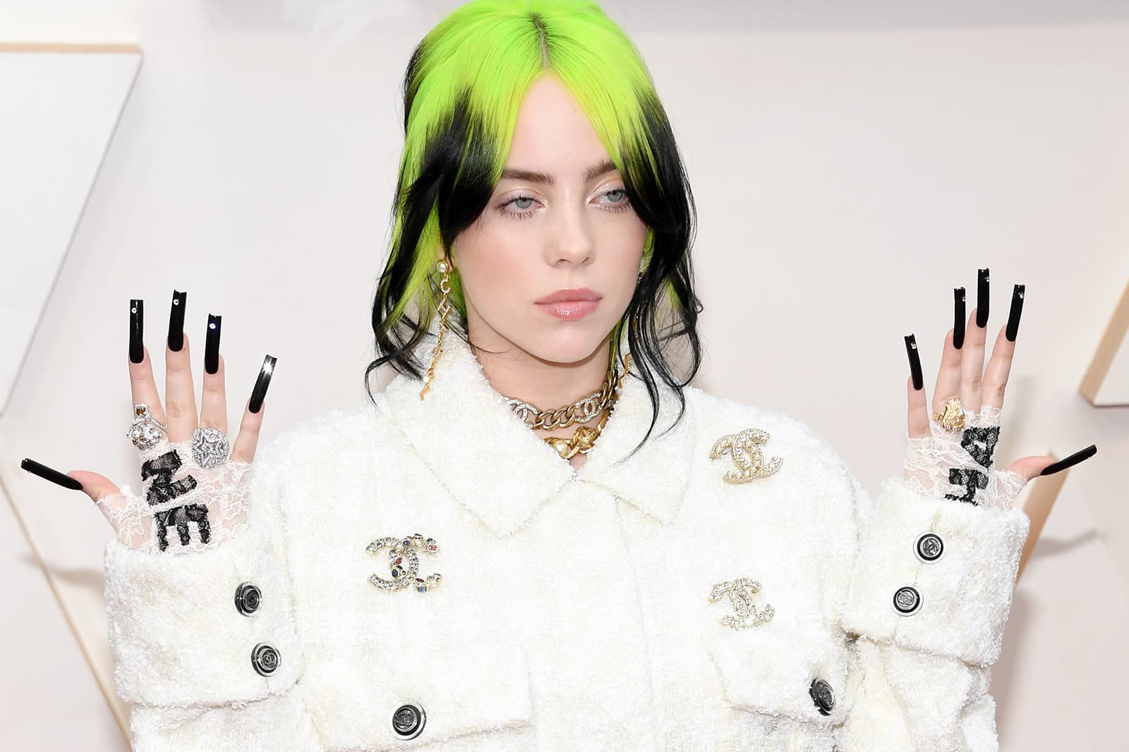  Singer Billie Eilish wearing Chanel brooches and mismatched white metal and yellow gold rings at the 2020 Oscars