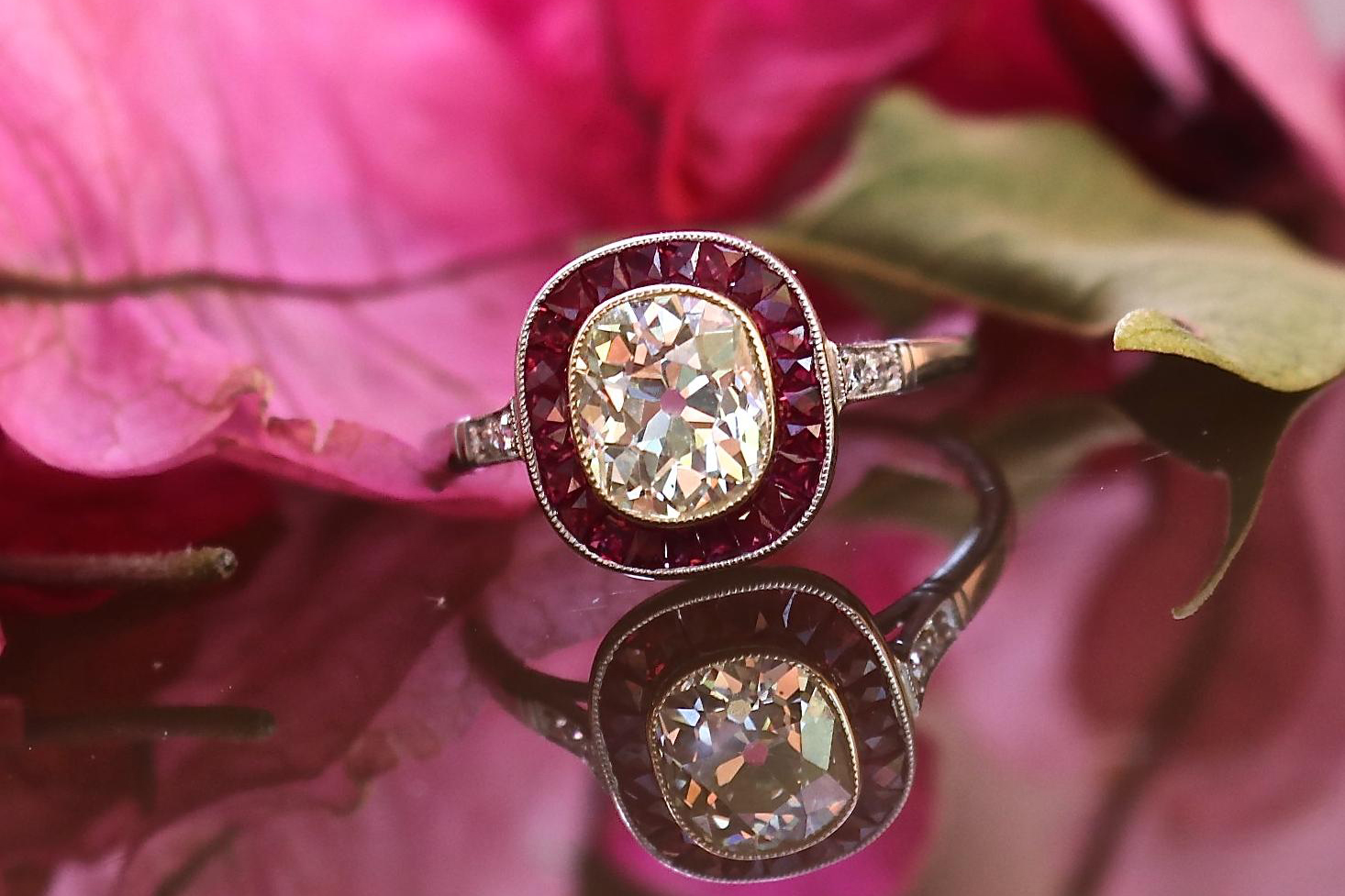  Jack Weir & Sons Art Deco style 1.44 carat 'Old Mine' cut diamond ring with a ruby halo, set in platinum