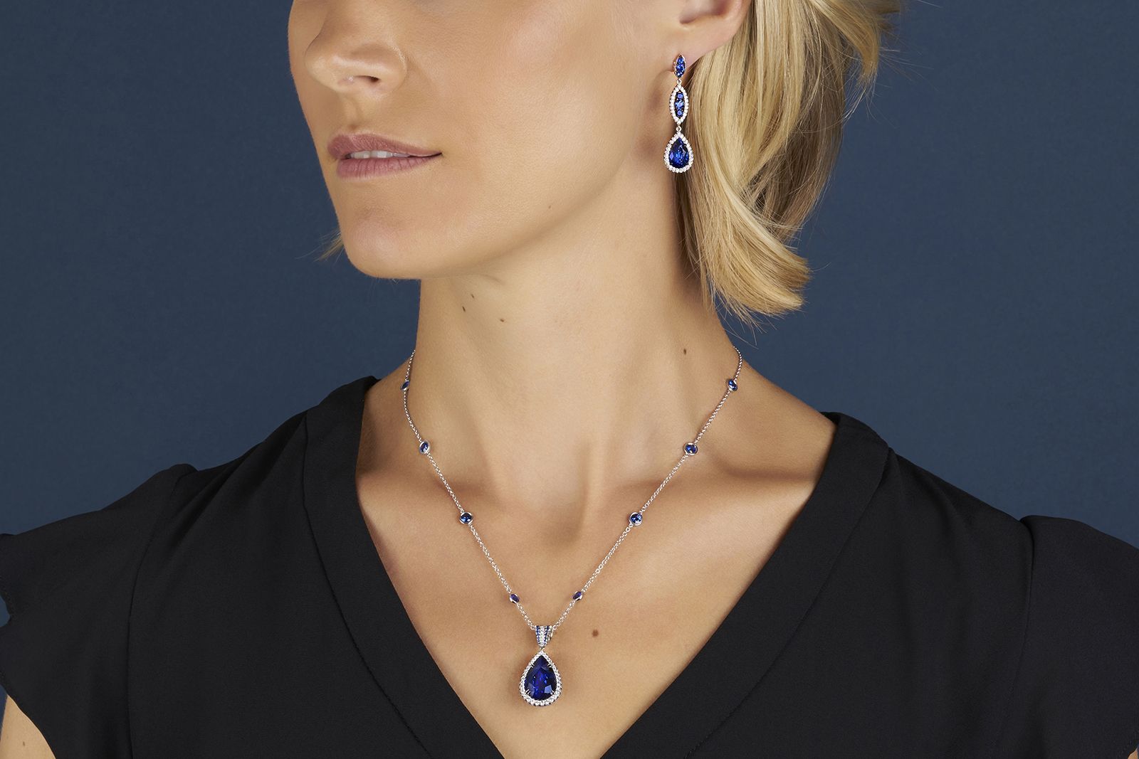Omi Privé platinum pendant featuring a 13.34 carat pear-shape sapphire accented by 1.57 carats of round sapphires and diamonds