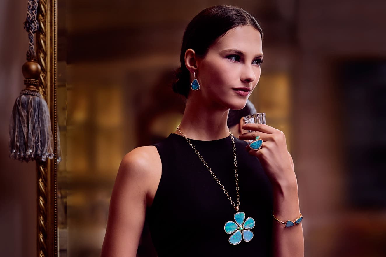 A model wears the TAYMA Fine Jewellery opal, Paraiba tourmaline and diamond Flower pendant in 18k yellow gold