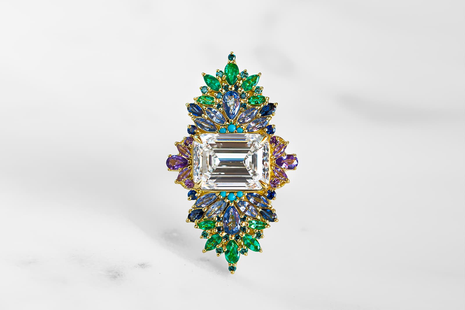  Maggi Simpkins Peacock ring with an emerald-cut white diamond centre stone with sapphires, emeralds and teal blue diamonds