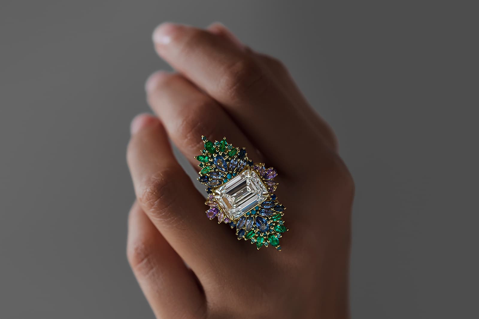 Maggi Simpkins Peacock ring with a 10.12 carat emerald-cut white diamond centre stone with sapphires, emeralds and teal blue diamonds in 18k yellow gold
