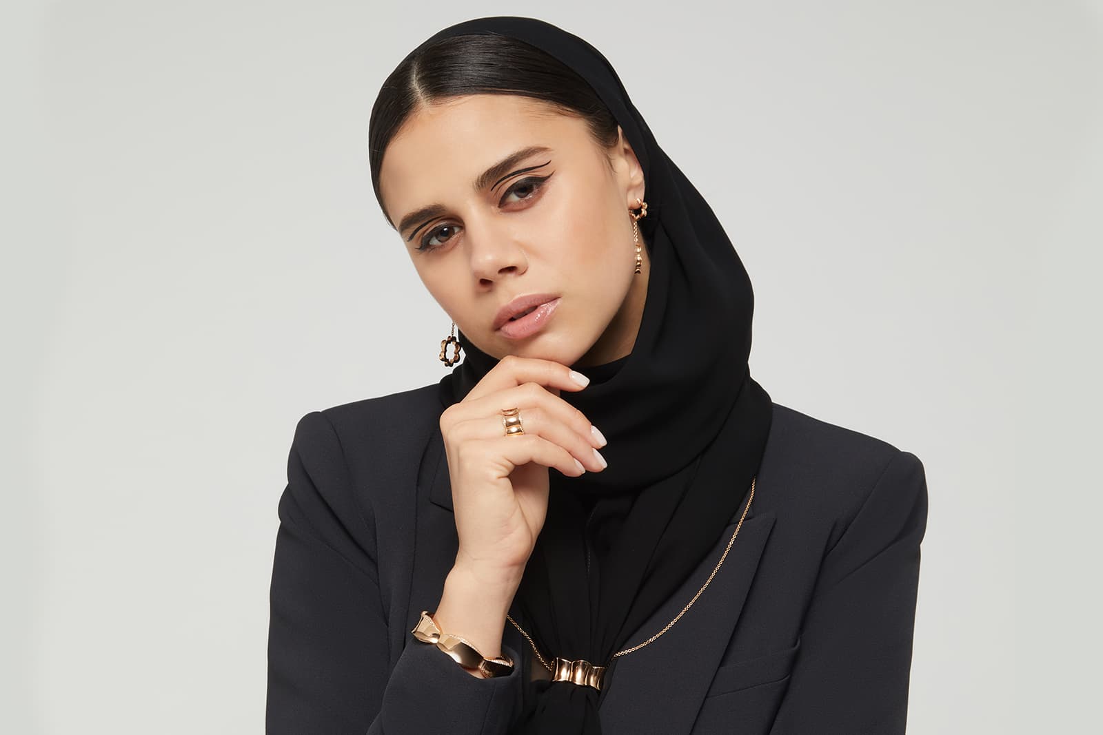 A model wears Fullord's Lotus scarf ring alongside the Lotus bracelet and matching earrings