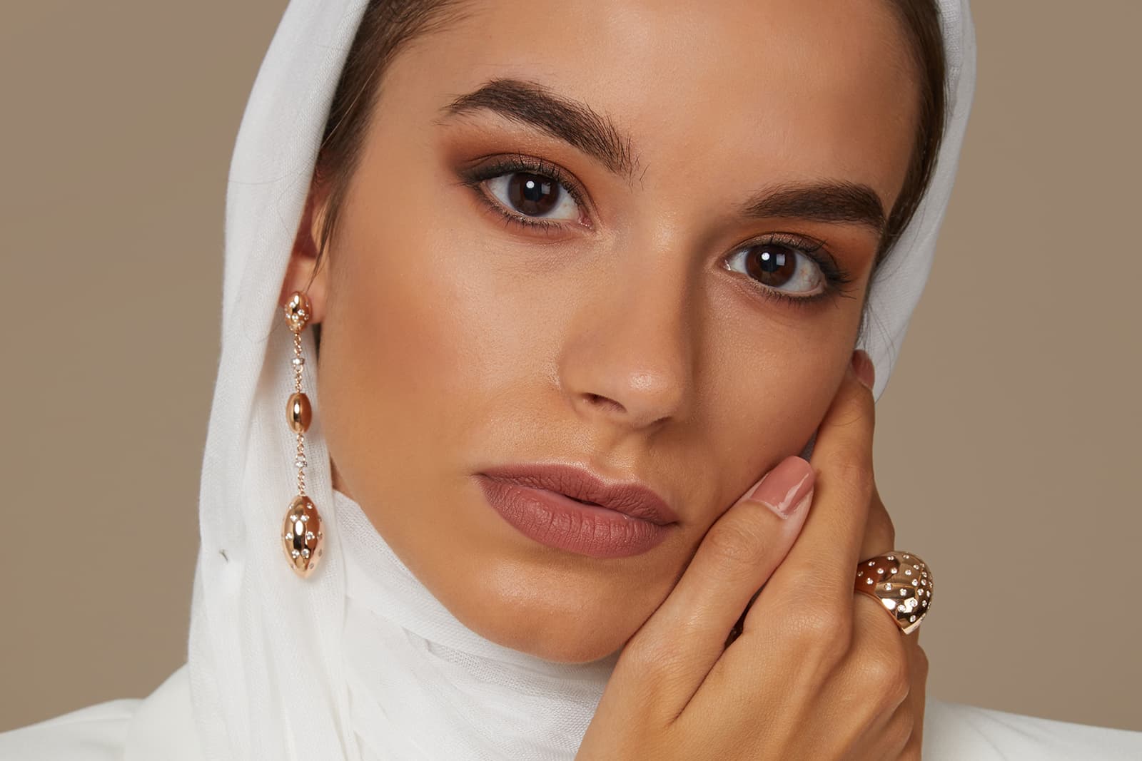  A model wears the Fullord Chrysalide collection, including a scarf ring, ring, bracelet and a pair of earrings in 18k gold
