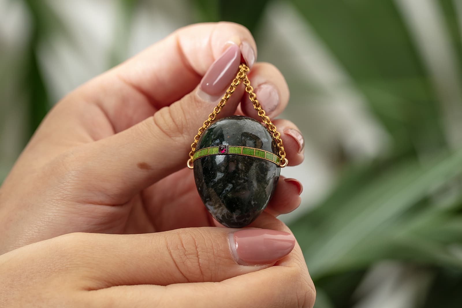 Fabergé pendant pill box in moss agate (circa. 1899-1903) decorated with guilloche enamel, gold and set with a cabochon ruby, from the Harry Woolf collection to be sold by Christie’s London in November 2021