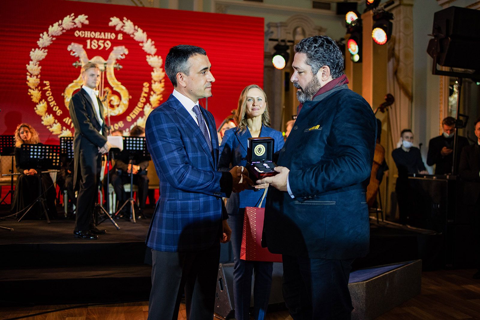 Alexander Chamovskikh presents Grand Duke George Mikhailovich with a diamond brooch in the shape of his family monogram