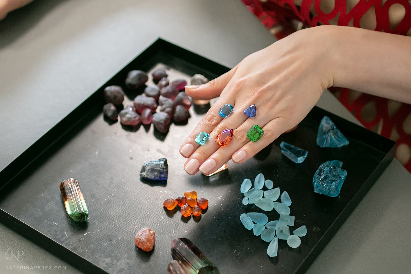 A selection of cut gemstones by HC Arnoldi including Nigerian Paraiba-like tourmaline, Santa Maria-colour aquamarine from Mozambique, tanzanite, Nigerian green tourmaline, and Mandarin garnet, alongside rough material