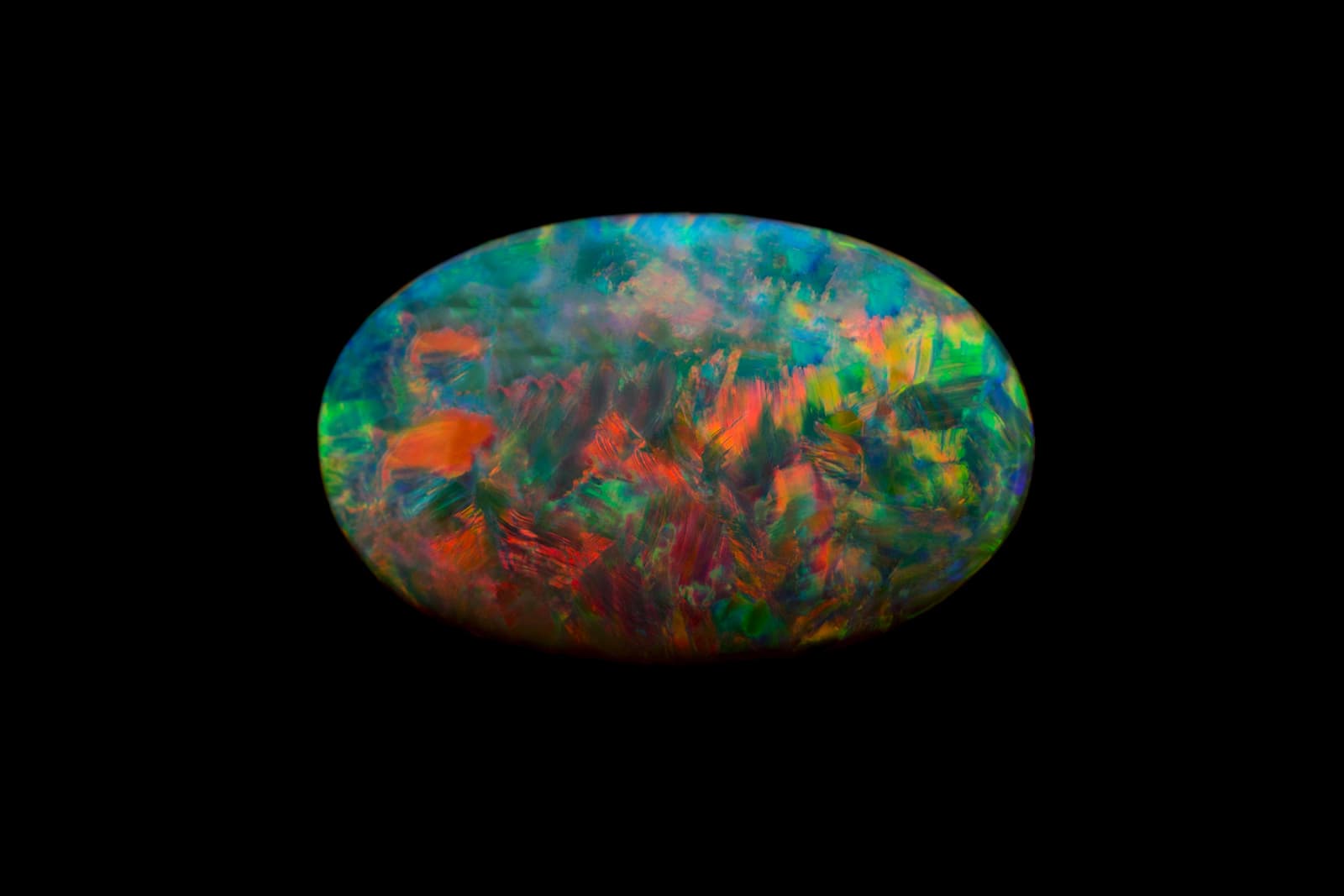  Red brushstroke-like patterns in an Australian black opal, courtesy of IMAGEM