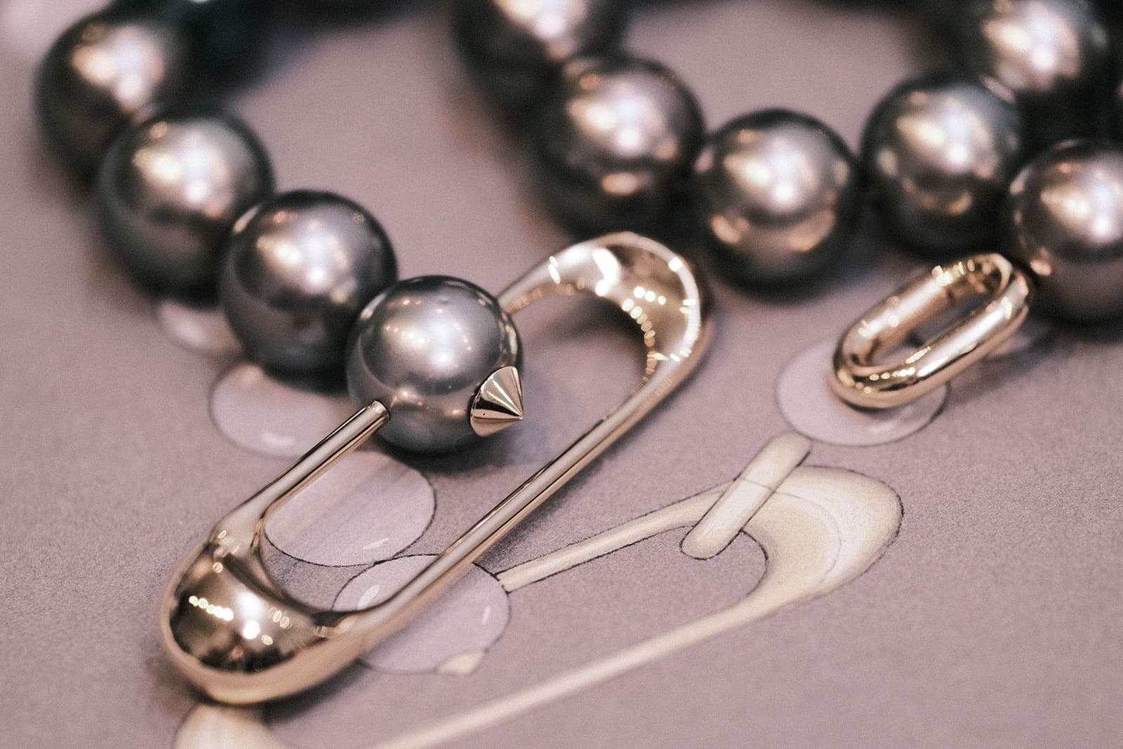  A completed bespoke necklace by Hannah Martin alongside its original design sketch 