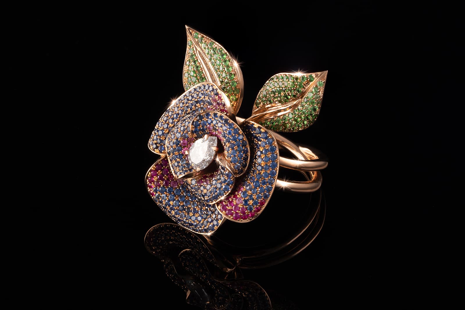 Nigel O’Reilly Blue Rose ring with a 0.50 carat pear-shaped diamond set in 18k rose gold with tsavorite garnets, blue sapphires and rubies 