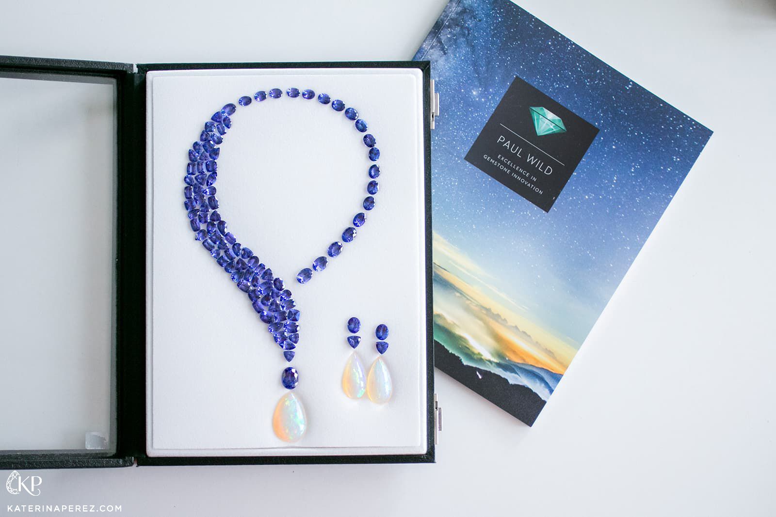 A necklace and earring gemstone layout by Paul Wild featuring tanzanites and pear-shaped opals