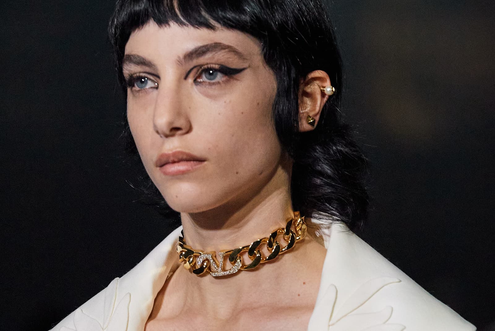 A model wears a yellow gold and gem-set chain choker on the catwalk for Valentino SS22