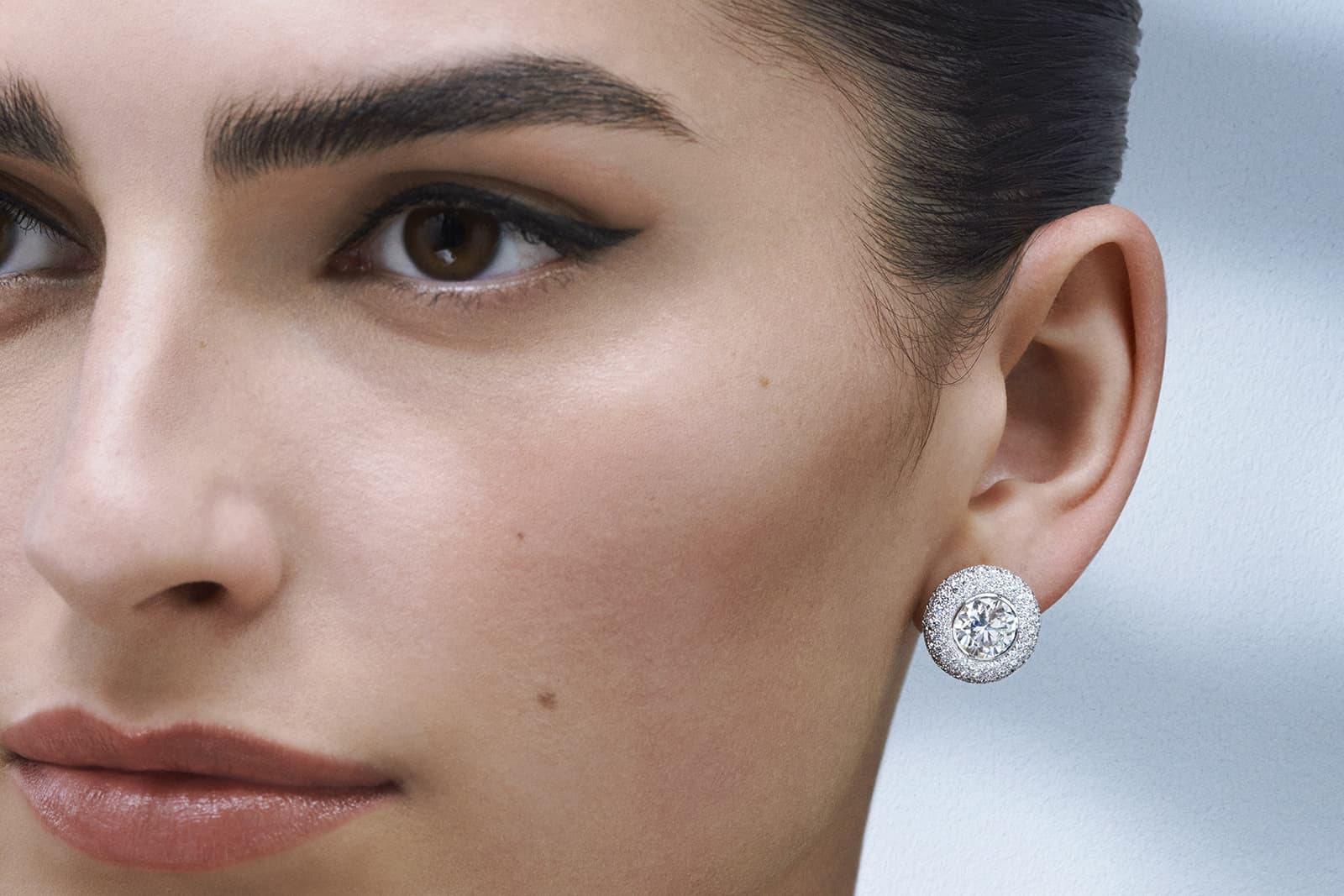  A model wears the De Beers Jewellers The Alchemist of Light High Jewellery Atomique stud earrings