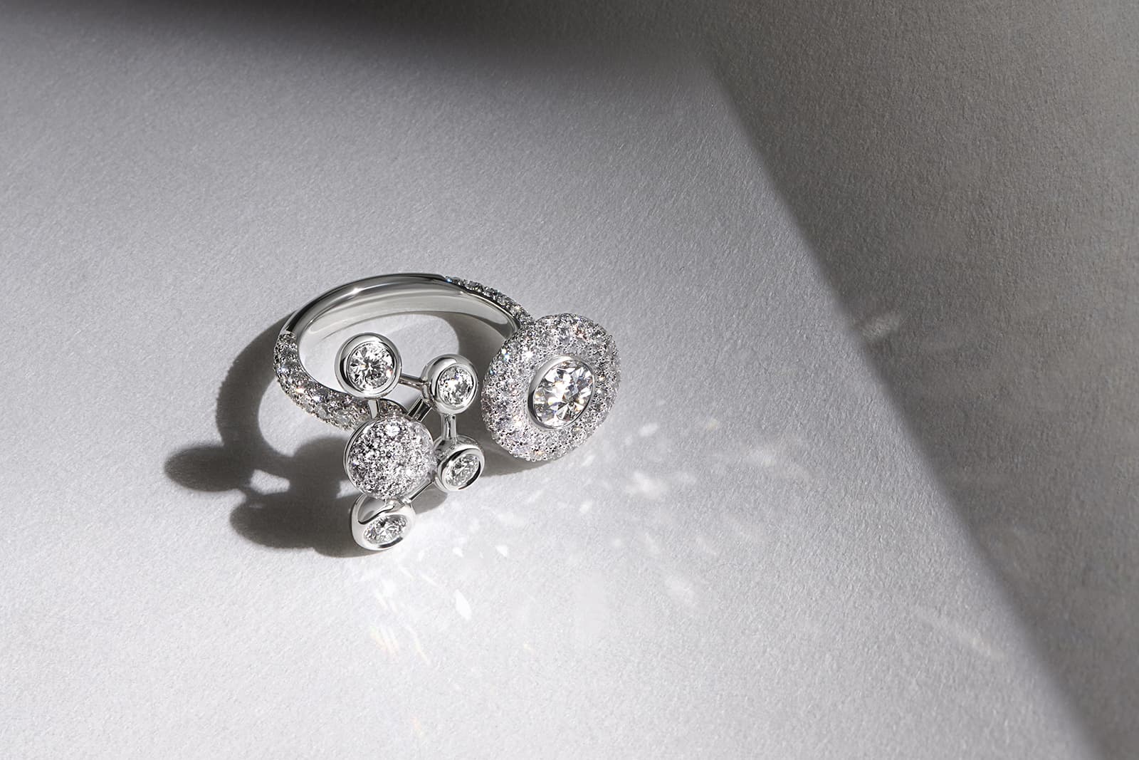  De Beers Jewellers The Alchemist of Light High Jewellery Atomique double open ring with two contrasting motifs that appear to float like satellites
