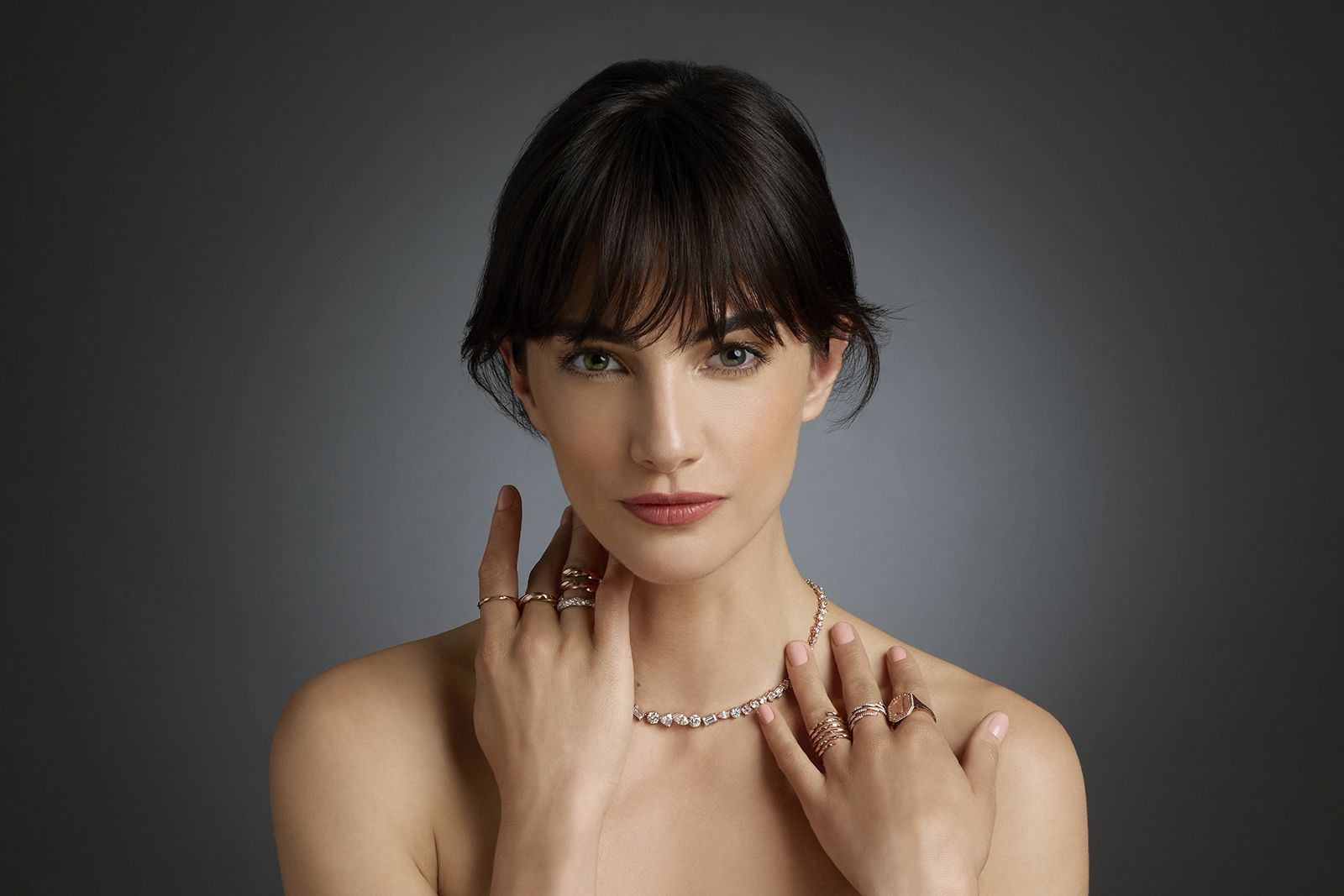 A model wears D. GREGORY jewellery, including the Fantasia necklace, Vesper collection rings and a signet ring