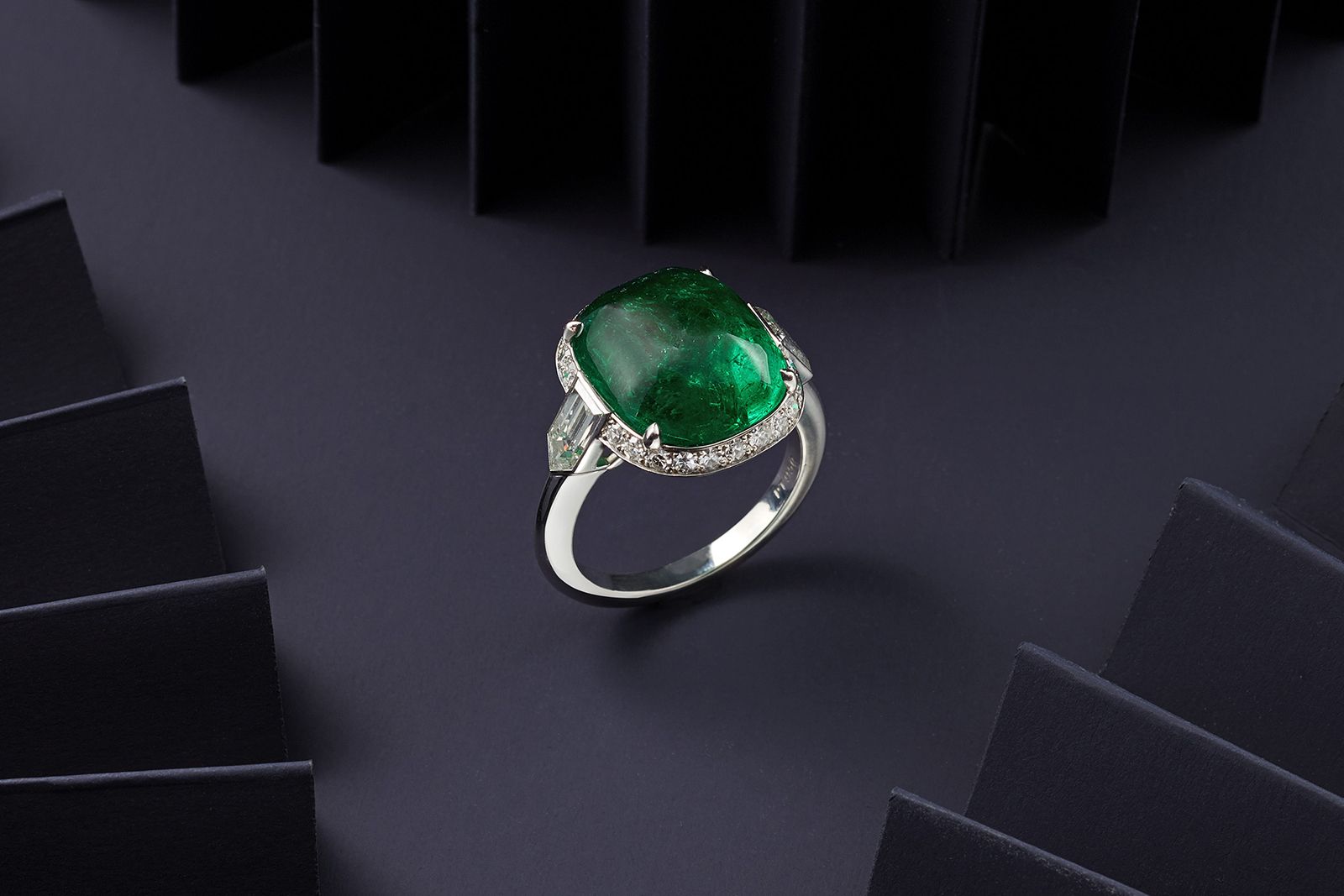 Hancocks cocktail ring with an 8.59 carat sugarloaf Colombian emerald cabochon with shield-shaped diamond shoulders, due to be sold during the Bonhams London Jewels auction