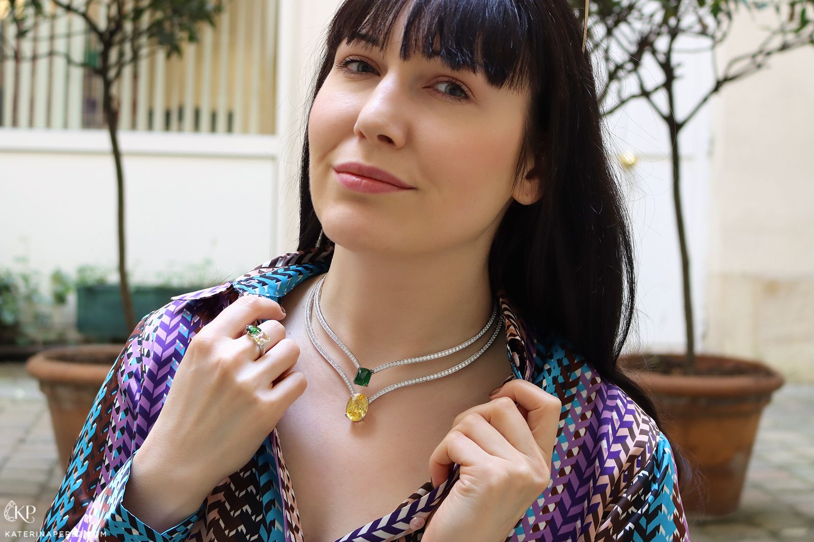 Katerina Perez wearing two Maison Avani necklaces - one with a yellow sapphire and the other with a tsavorite garnet